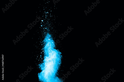 Abstract blue powder splatted on white background. Freeze motion of blue powder exploding on blackbackgrund.