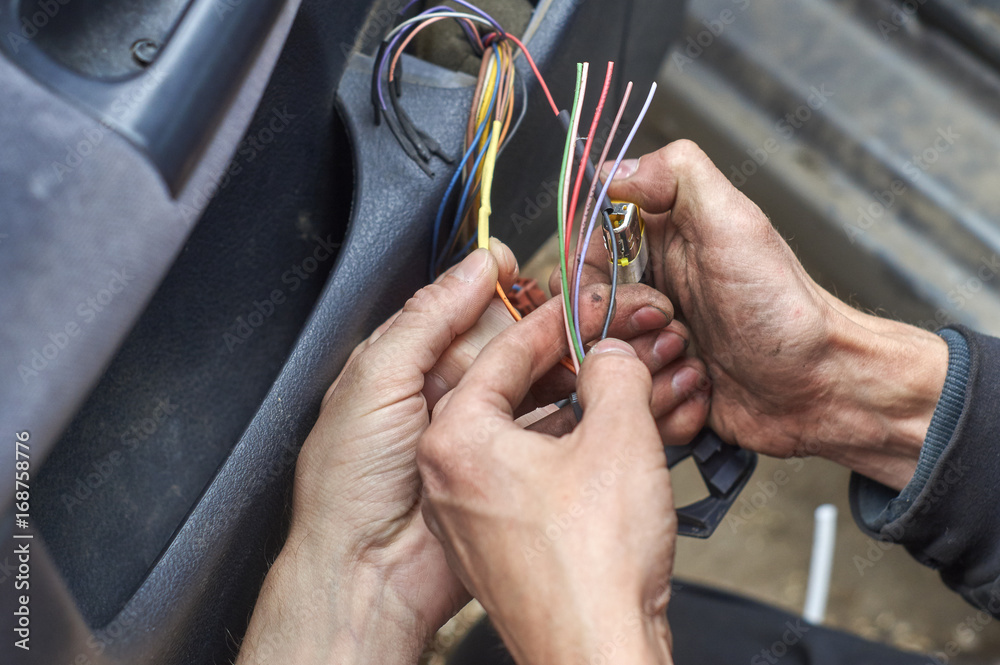 Mechanics connecting electrical wires in the door of car using a