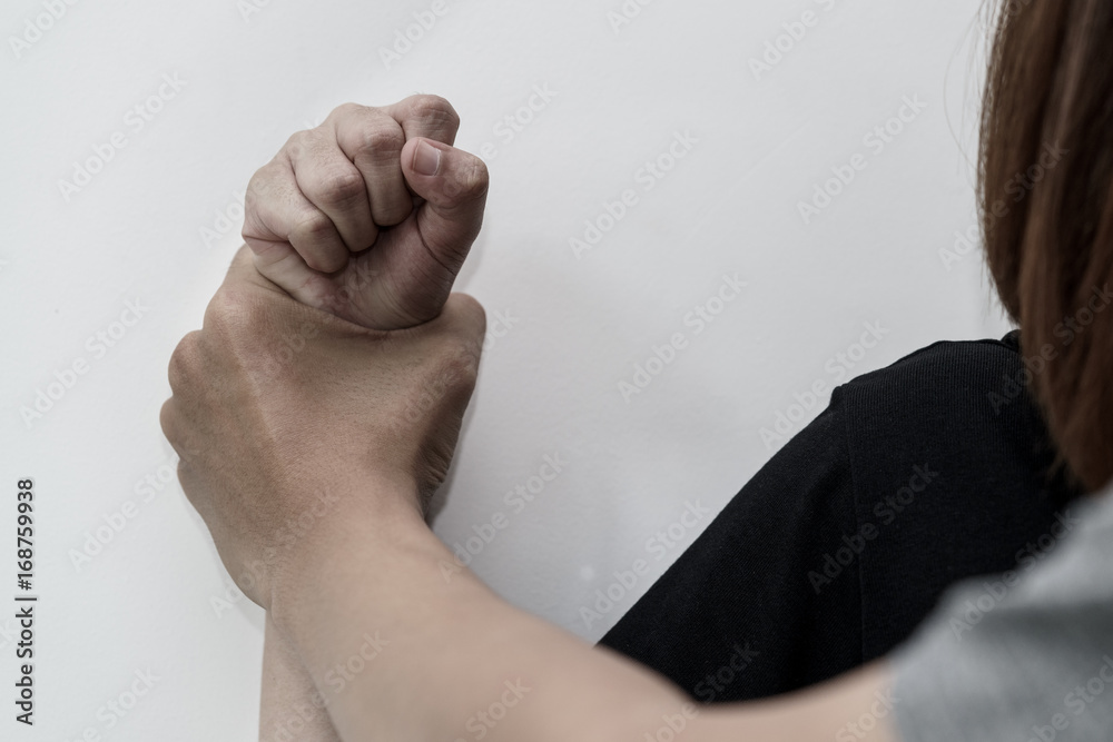 Man hand oppressing or pressing woman wrist on the wall - woman violence concept. Man hand oppressing or pressing woman wrist on the wall - woman violence concept.