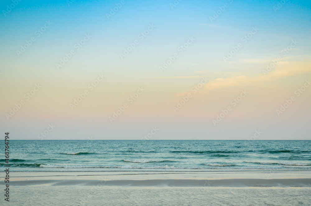Tropical beach, sand, wave at sunset or sunrise time. Summer holiday concept.
