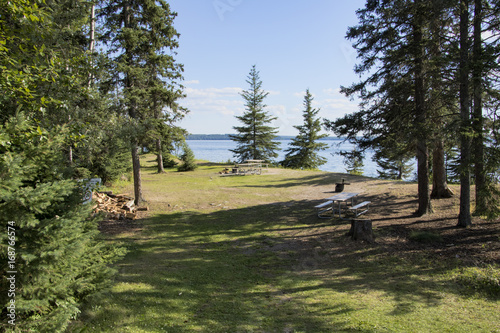 Campsite with picnic and campfire areas next to the hiking trail to Grey Owl's cabin on the shore of Waskesiu Lake in Prince Albert National Park in Saskatchewan Canada. photo