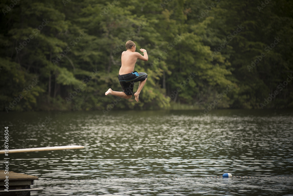 Kid jumping on diving board Kid jumping on diving board