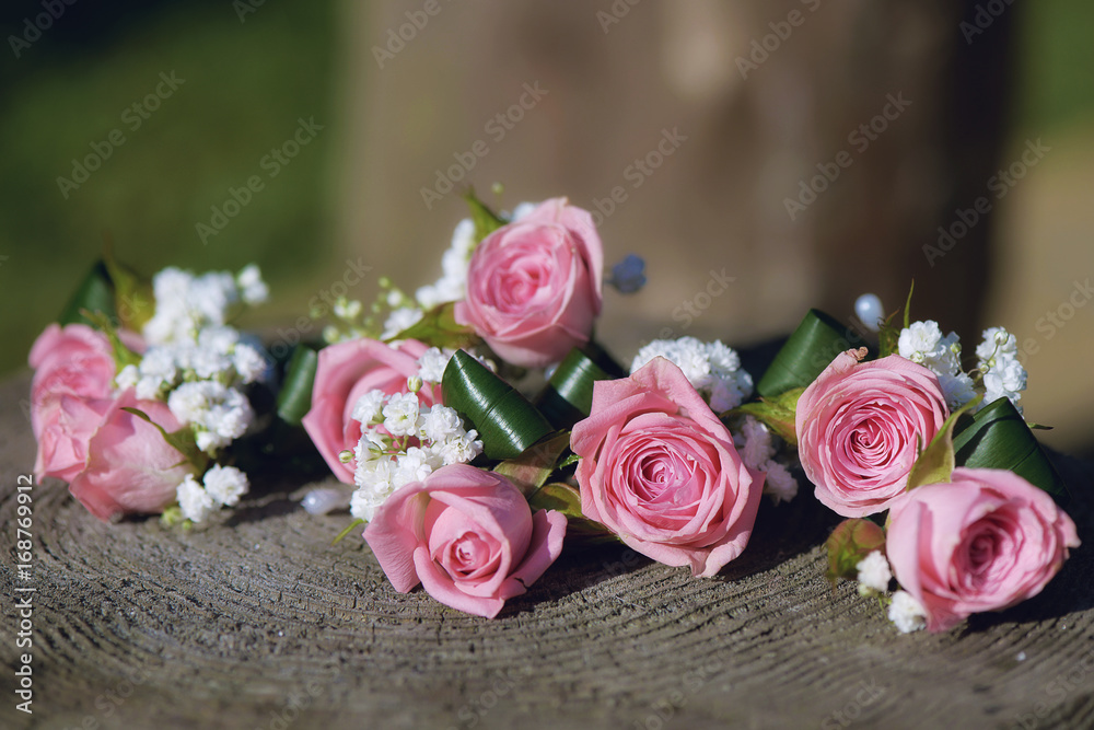 Flower arrangement for wedding centerpiece featuring small pink roses and baby's-breath, positioned on a tree stump, with shallow depth of field Flower arrangement for wedding centerpiece featuring small pink roses and baby's-breath, positioned on a tree stump, with shallow depth of field