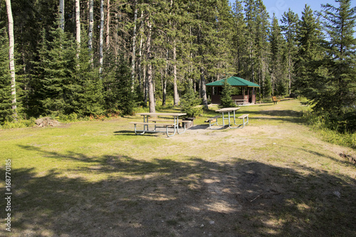 Campsite with picnic and campfire areas next to the hiking trail to Grey Owl's cabin on the shore of Waskesiu Lake in Prince Albert National Park in Saskatchewan Canada. photo