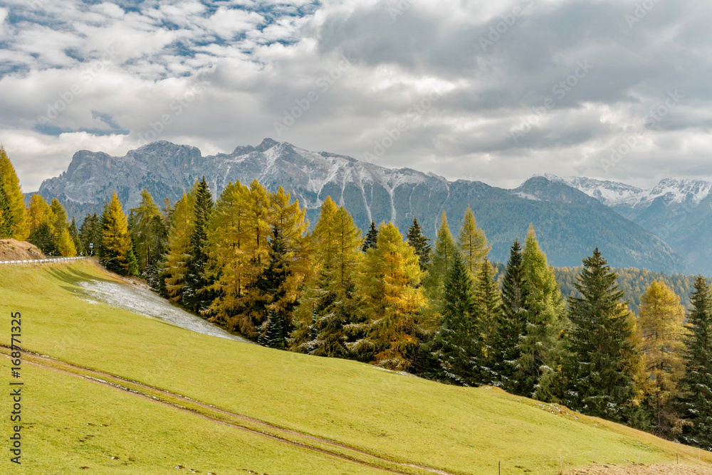 Autumn in the mountains. Funes Valley with snowy landscapes and colorful forests