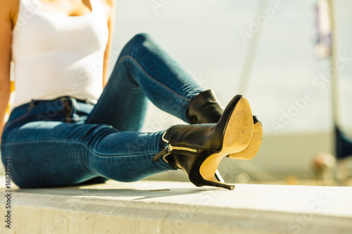 woman in denim pants heels shoes outdoor photo