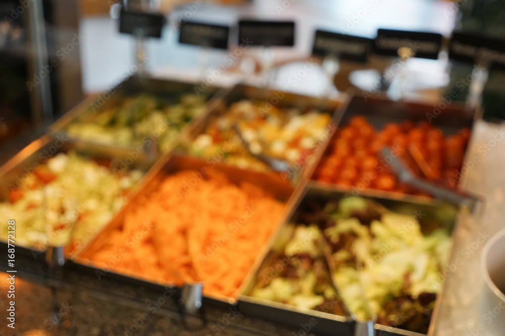 Stand with delicious food in cafeteria, blurred view