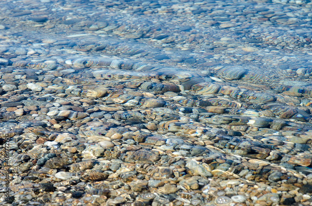 pebble stones into the water in the lake Baikal
