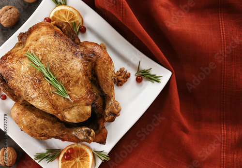 Plate with tasty whole roasted turkey on table