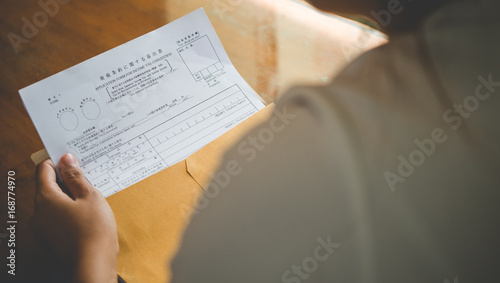 Women are opening an envelope document with japan tax document contract in business and taxation concept,vintage style . photo