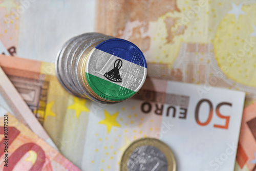 euro coin with national flag of lesotho on the euro money banknotes background.