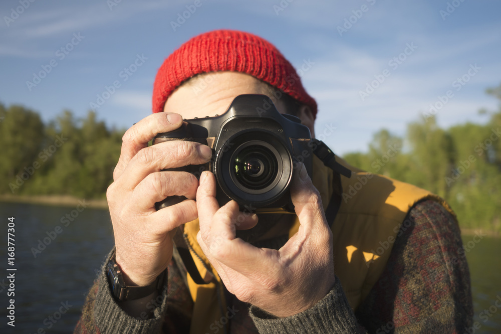 Closeup Portrait of a Man Taking a Picture with Professional Photo Camera on a Lake. Closeup Portrait of a Man Taking a Picture with Professional Photo Camera on a Lake.