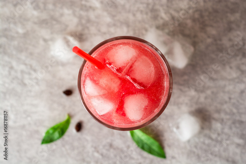 Fresh watermelon smoothie with ice and mint in glass on gray stone background