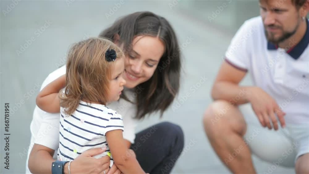 Young Parents Talk to Their Sad Daughter Spending Time Together Outdoors During Weekend in the City in the Summer Time. Young Parents Talk to Their Sad Daughter Spending Time Together Outdoors During Weekend in the City in the Summer Time.