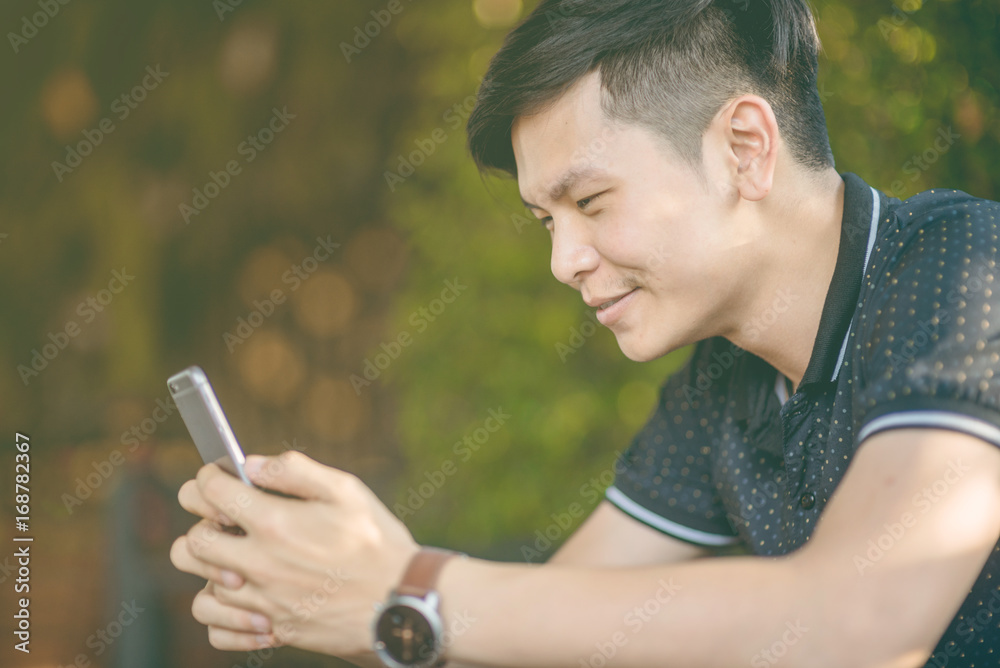 Attractive businessman using smartphone while sitting on sofa at his home.Concept of young people working mobile devices.Closeup with a selected focus.Blurred background. business. Attractive businessman using smartphone while sitting on sofa at his home.Concept of young people working mobile devices.Closeup with a selected focus.Blurred background. business.