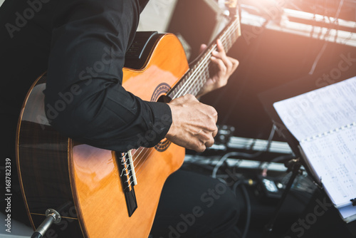 The musician is sitting guitar