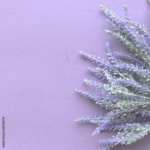 Lavender flower on purple wooden background.