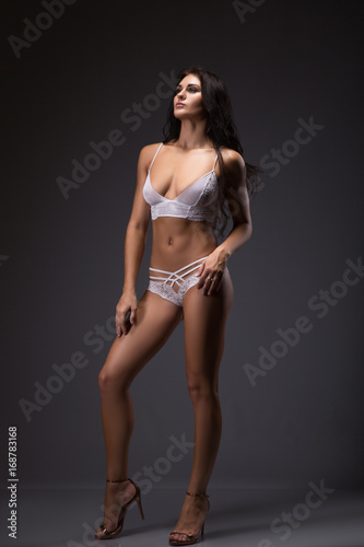 Portrait of brunette woman with Perfect body on a gray background in a sexy lingerie © Volodymyr Shcerbak