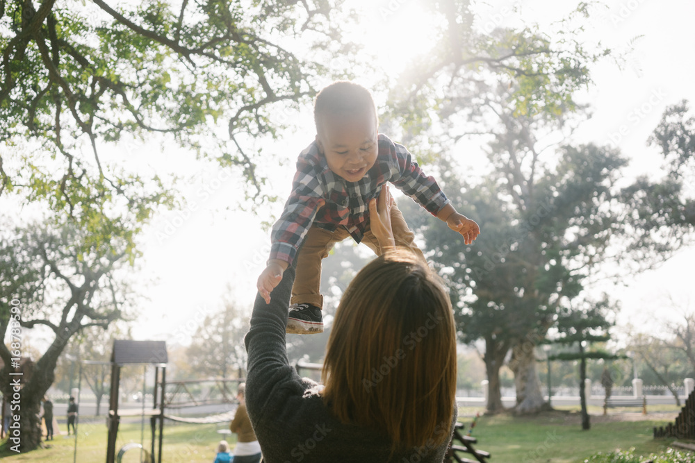 A mother holds her son in the air A mother holds her son in the air
