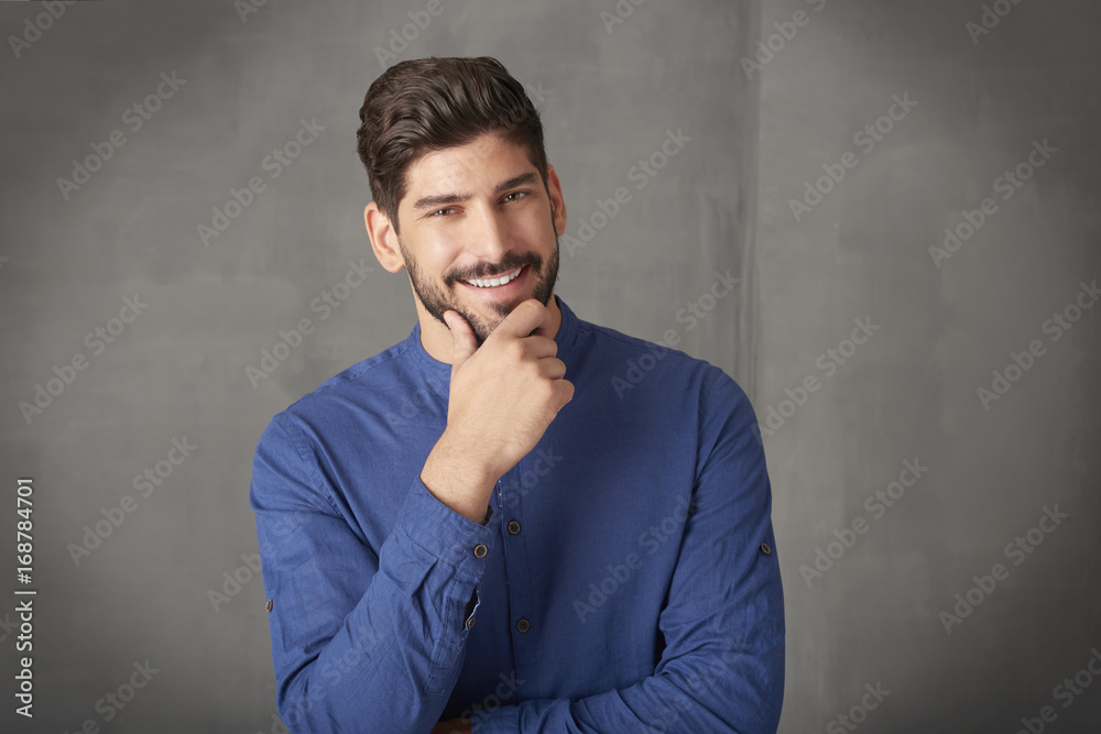 Confident young businessman portrait. Cropped shot a handsome young man standing at grey wall in studio. Confident young businessman portrait. Cropped shot a handsome young man standing at grey wall in studio.