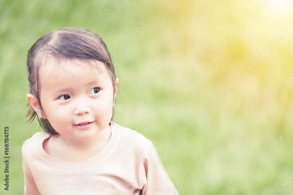 portrait of little girl playing in the green garden with warm tone and soft focus ,asian baby portrait of little girl playing in the green garden with warm tone and soft focus ,asian baby