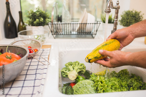 Man washes vegetables before eating photo