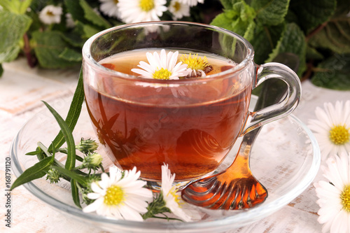 cup of tea with chamomile flowers on rustic background