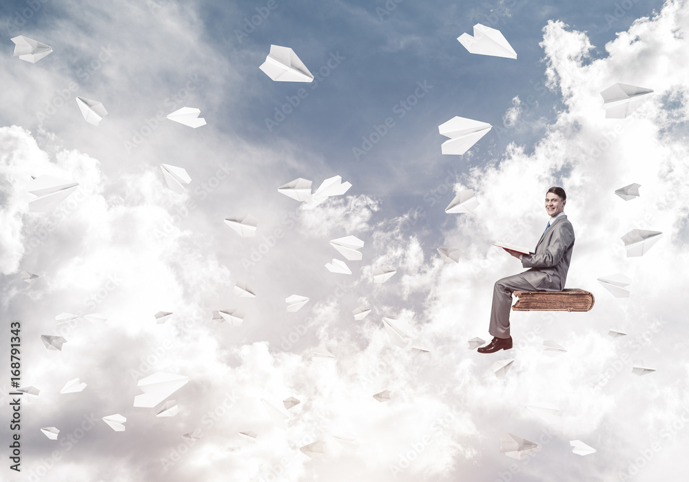 Businessman or student reading book and paper planes flying arou Businessman or student reading book and paper planes flying arou