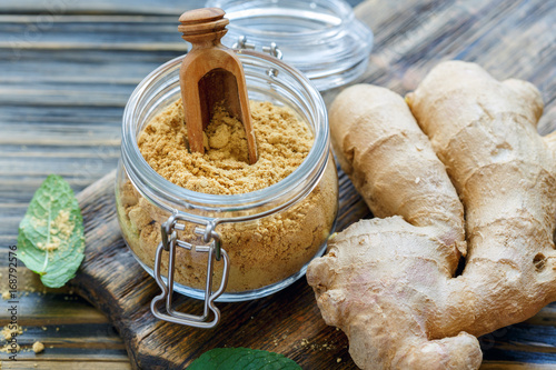 Fototapet Ginger powder in glass jar and ginger root.
