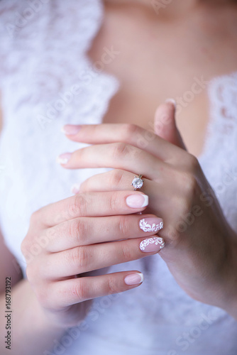 Vertical shot with bride s hands in focus  showing proudly the wedding or engagement ring. Wedding concepts  details  ideas and themes  bride morning preparation.