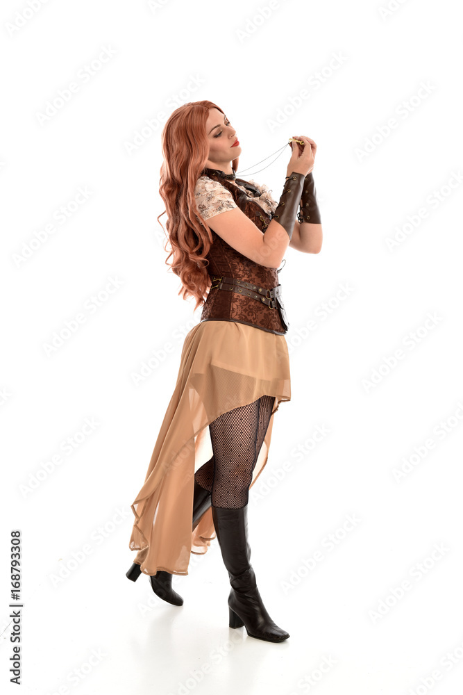 full length portrait of a red haired lady, wearing a steampunk inspired outfit, isolated on white background. full length portrait of a red haired lady, wearing a steampunk inspired outfit, isolated on white background.