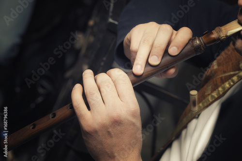 the musician plays on the traditional Middle Eastern and Asian brass musical instrument duduk