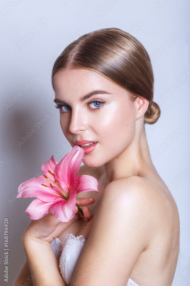 Beauty face of young woman with flower. Beauty treatment concept. Portrait over white background Beauty face of young woman with flower. Beauty treatment concept. Portrait over white background
