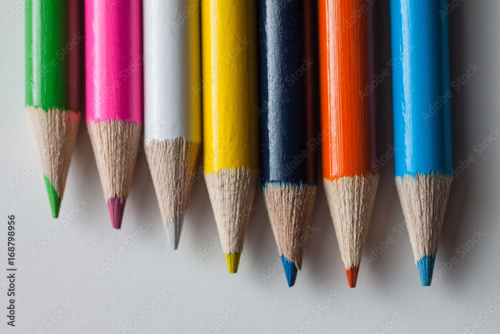 Close-up of a group of multicolored pencils on a white surface Close-up of a group of multicolored pencils on a white surface