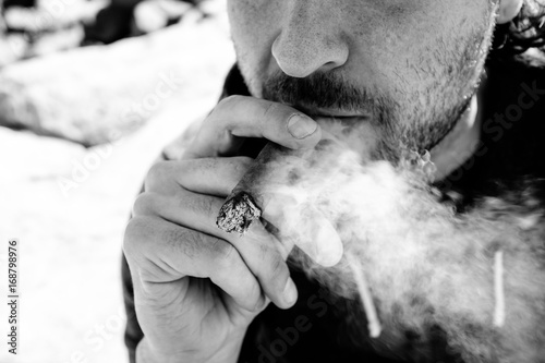 Black and white man smoking cigar outside photo
