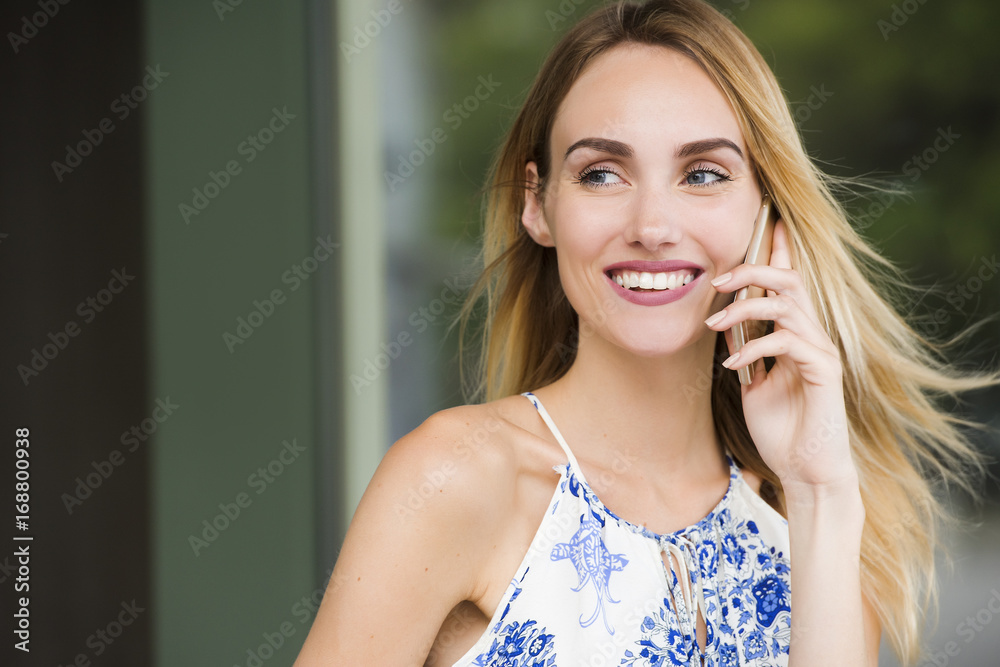 Fototapeta premium Beautiful Young Woman is feeling happy while talking to the phone