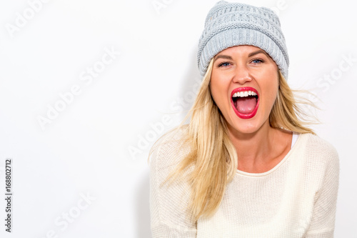 Happy young woman in winter clothes on a white background