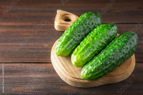 Fresh raw green cucumbers on a wooden table
