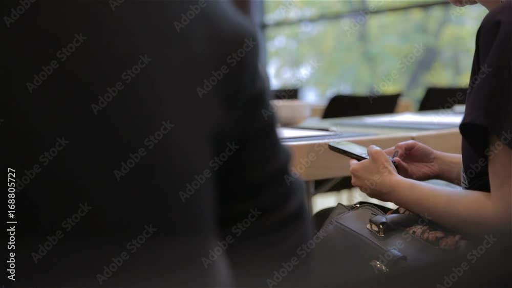 Person typing on smartphone at conference room close up Person typing on smartphone at conference room close up