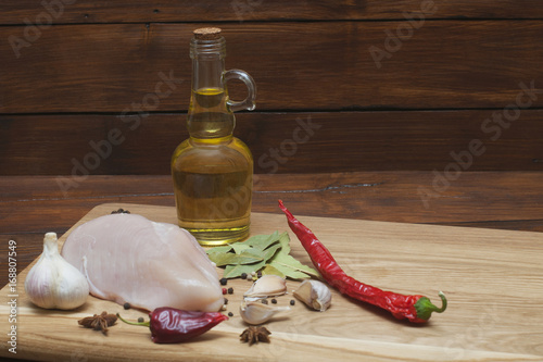 Fresh meat. Chicken fillet with chili, spices and rosemary on a cutting board. photo