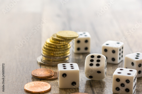 Dices and coins stack on wooden table