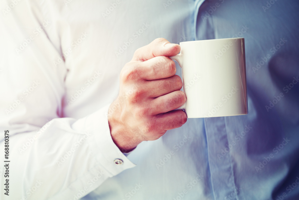 businessman hand holding coffee or tea mug. Blank space for logo or text businessman hand holding coffee or tea mug. Blank space for logo or text