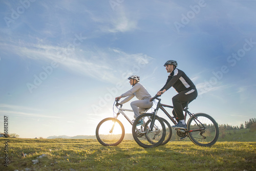 Fototapeta Naklejka Na Ścianę i Meble -  Happy mountainbike couple outdoors have fun together on a summer afternoon