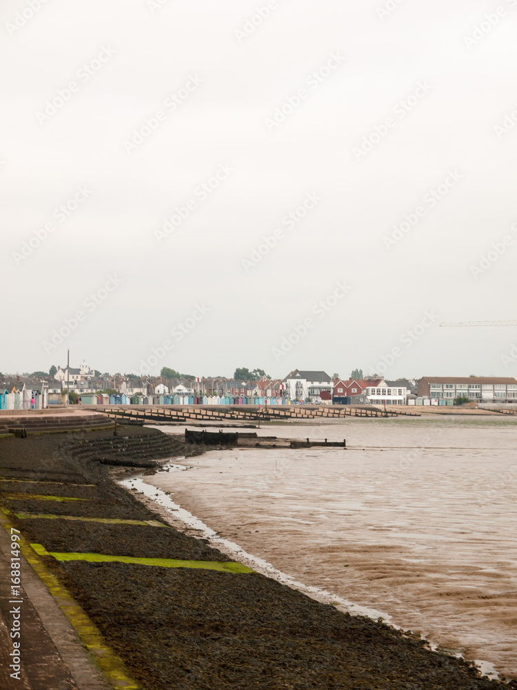 brightlingsea sea front with seaweed, groynes, houses and huts