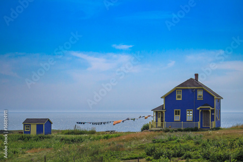 Cute blue house with washing line facing the see