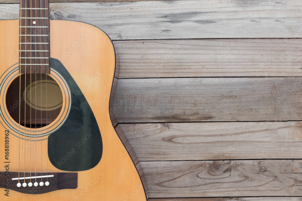 Obraz premium Acoustic guitar on wood desk background