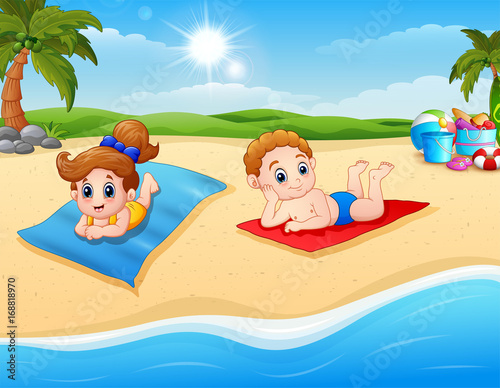 Children sunbathing on the beach mat