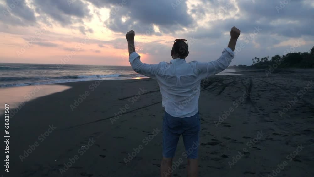Happy man raising arms in triumph on beach, super slow motion 240fps
Happy man raising arms in triumph on beach, super slow motion 240fps