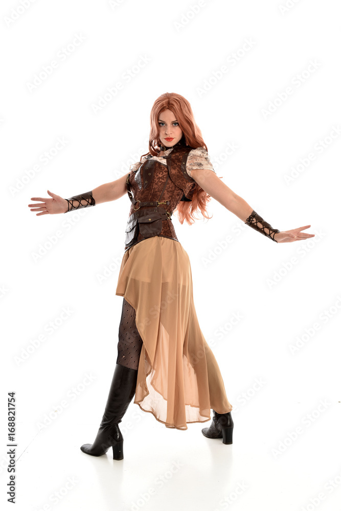 full length portrait of red haired lady wearing steampunk inspired outfit, standing pose against a white background.