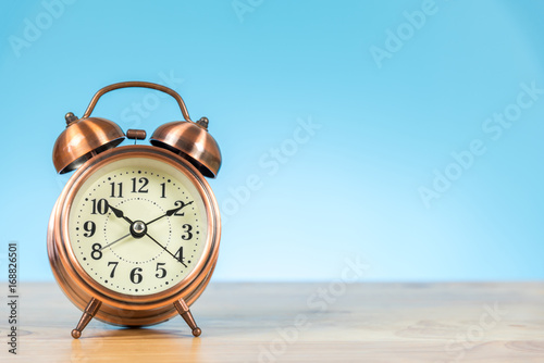 alarm clock on the table and blue background